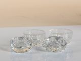 two clear glass bowls sitting on top of a white table