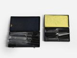 two different pens in a case on a white surface