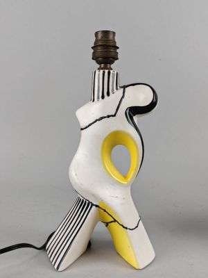 une image représentant une lampe sur laquelle repose une main