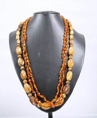 a multi strand necklace with brown beads on a black mannequin