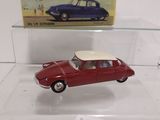 a small red car with a white top in a display case