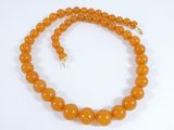 an orange jade bead necklace with a gold clasp