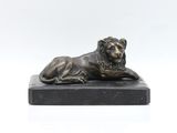 a bronze statue of a lion on a marble base
