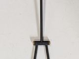 a black and gold candle holder on a white wall