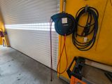 an image of a garage with a hose attached to the side of the garage door