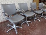quatre chaises de bureau alignées en rang devant un mur