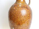 a brown vase that is sitting on a white surface