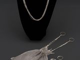 un collier, une bague et des boucles d'oreilles posés sur un présentoir pour mannequin