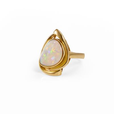a gold ring with a white oplite stone in the center