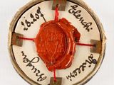 a red wax seal sitting on top of a white plate