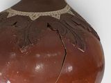 a large brown vase with a design on it