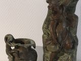 une statue représentant un homme et un vase posé sur une table