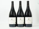 trois bouteilles de vin sont alignées sur une surface blanche
