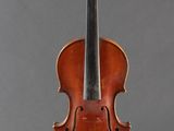 an old violin sitting on a stand against a gray background