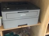 a printer sitting on top of a wooden shelf in a room