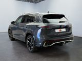 the rear view of a grey volkswagen suv parked in a showroom
