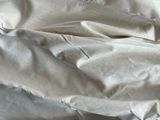 a bed with a white comforter and white sheets on it