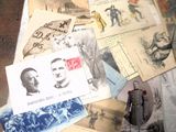 de nombreuses cartes postales anciennes posées sur une table, à côté d'une statue représentant un homme