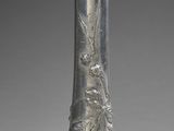 a silver vase with a floral design on it