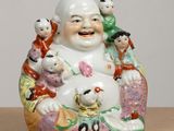 a figurine of a laughing buddha with a group of children