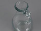 a clear glass vase with a small glass object inside of it