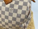a white and blue checkered bag sitting on top of a yellow cloth