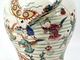 a vase with a painting on it sitting on a table