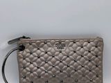 a small grey purse with studded details on the front