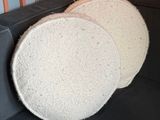 two round white sponges sitting on top of a black couch