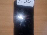 an image of a black cell phone sitting on top of a wooden table