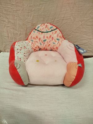 une peluche assise sur un oreiller