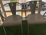 two chairs that are sitting on the grass in front of a balcony