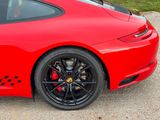 the rear end of a red sports car parked in a parking lot