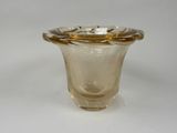 a glass vase with a gold rim sitting on a white surface