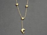 un collier plaqué or orné de trois cœurs et d'un oiseau, monté sur une chaîne