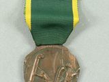 a bronze medal with a green ribbon around it