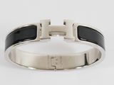 a close up of a black and white bracelet on a white surface