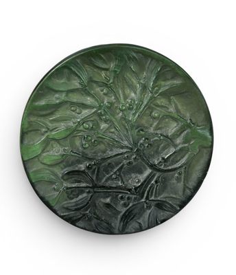 a green plate with a design on it on a white surface