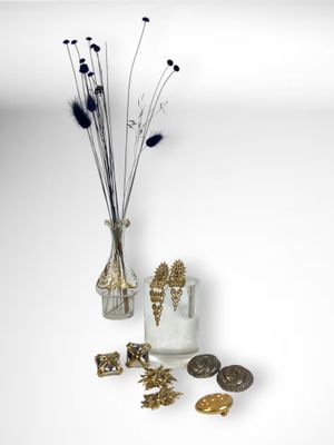 un vase contenant un bouquet de fleurs, à côté d'autres objets