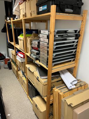 many boxes and boxes stacked on a shelf in a room