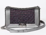 a small silver purse with a chain strap on a white background
