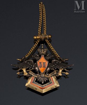 a close up of a gold and black pendant with two birds on it