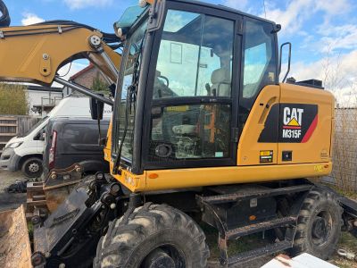 a picture of a cat excavator parked in a yard