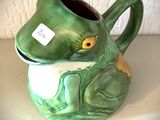un vase en forme de grenouille verte, muni d'une étiquette