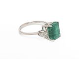 a close up of a ring with a green stone on it