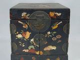 une petite boîte noire décorée de fleurs et d'oiseaux