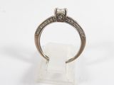 a close up of a diamond ring on a clear display stand