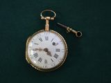 une montre à gousset en or à laquelle est attachée une clé