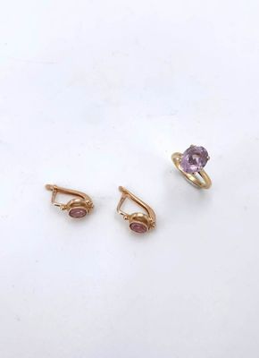 a pair of gold earrings and a ring with a purple stone
