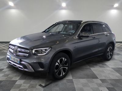 a grey mercedes glc is parked in a large room